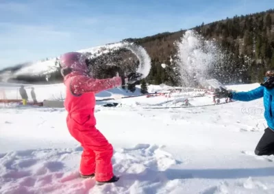 Enfant qui joue dans la neige avec son papa a Wiidoo Gliss dans les Vosges à La Bresse