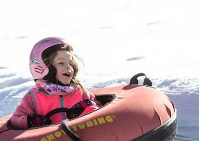 Enfant en hiver qui devale les pentes en bouée a Wiidoo Gliss dans les Vosges à La Bresse