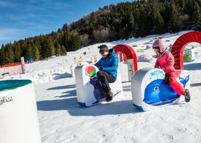 Papa et sa fille qui glisse sur des luge en forme d'animaux à Wiidoo'gliss a la Bresse dans les Vosges